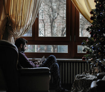 Homme près de son sapin, prenant soin de lui pour les fêtes de noël et l'hivers