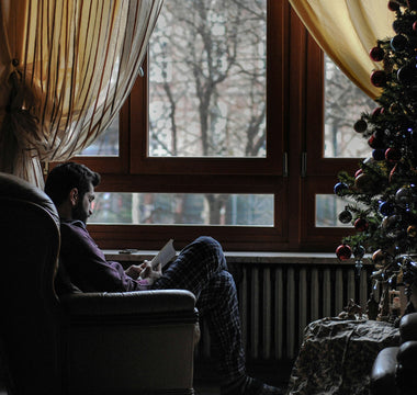 Homme près de son sapin, prenant soin de lui pour les fêtes de noël et l'hivers